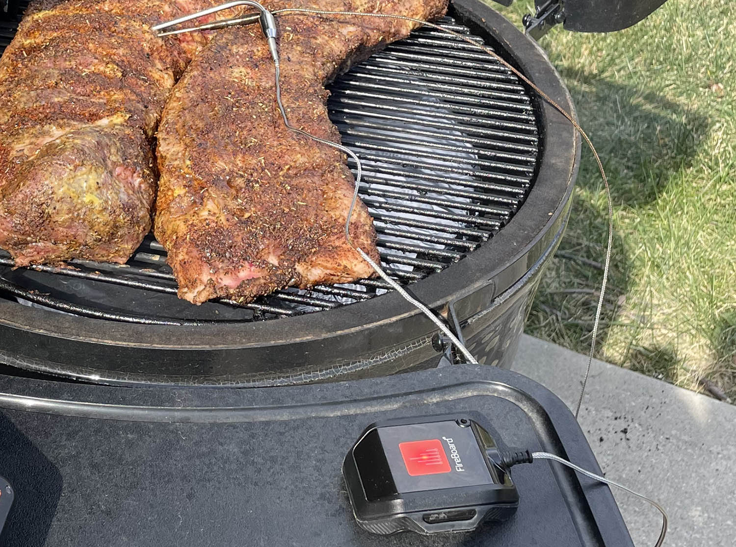 FireBoard Beacon monitoring the temperature of ribs on an outdoor grill.